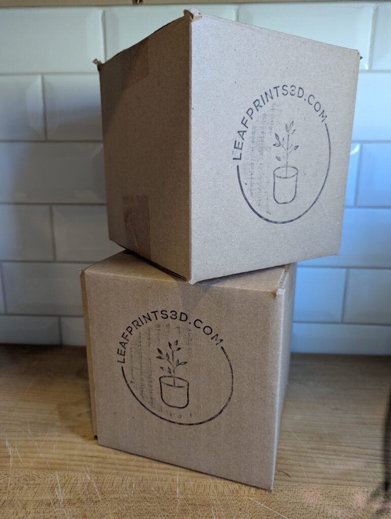 Two boxes stacked on top of each other with the leafprints.3d logo stamped on the sides